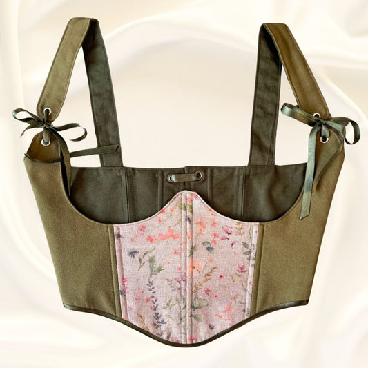 Корсет от зелен велур с бежов детайл на цветя и тъмно зелена подплата. Модел под бюста със зелени сатенени панделки на бежов сатенен фон