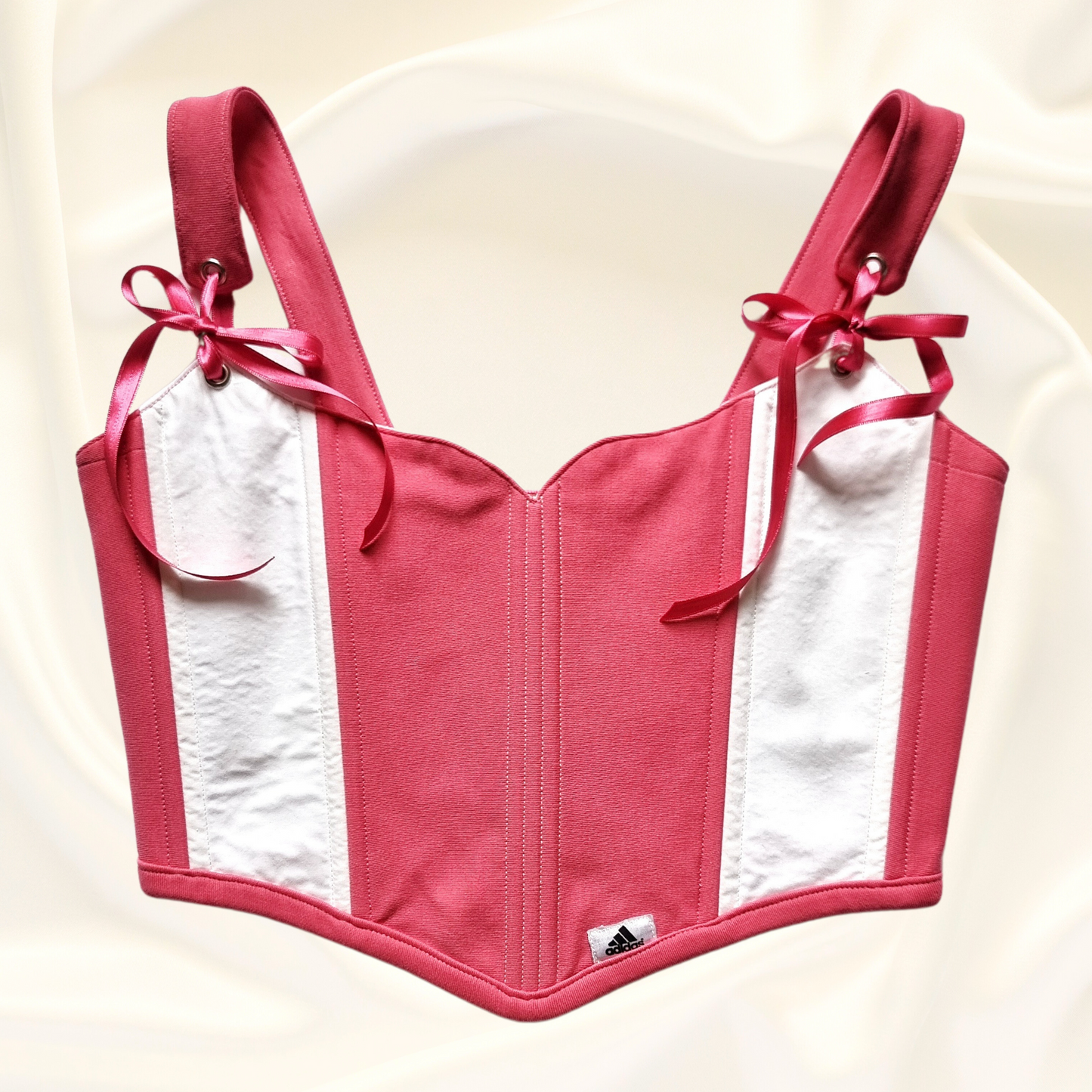 korset  v rozovo i bqlo ruchno izraboten s rozovi pandelki ot recikliran pamuk i metalni kapsi s adidas