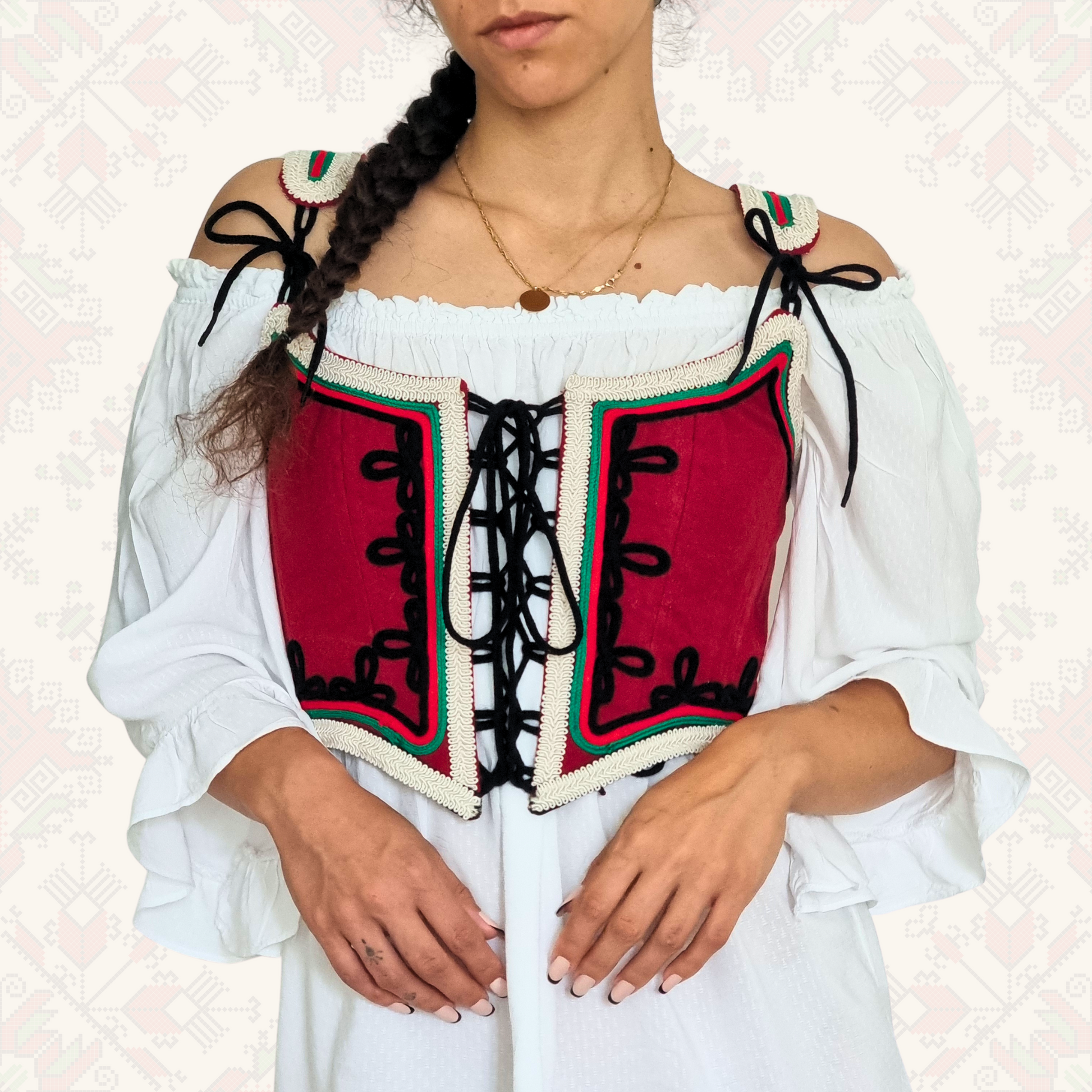 Korset rachna izrabotka v cherven cvqt  oblechen varhu bqla riza s gaitani v stil balgarska narodna nosiq i balgarskoto zname s vrazki ot cheren gaitan. 