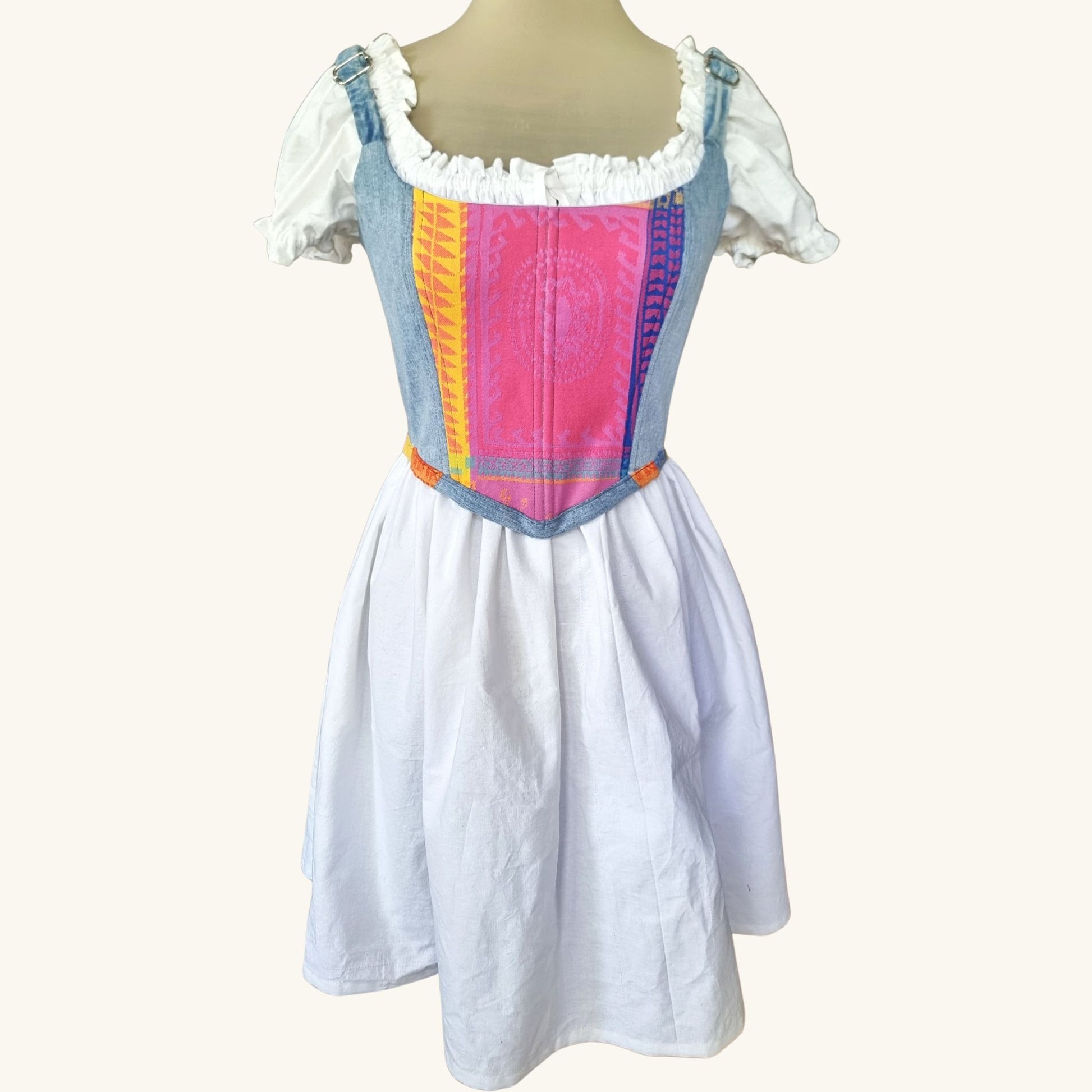 korset s regyuliruemi prezramki gledka otpred ot dankov plat, s centralen etno panel v rozovo, zhulto i sinio na maneken s bqla roklq