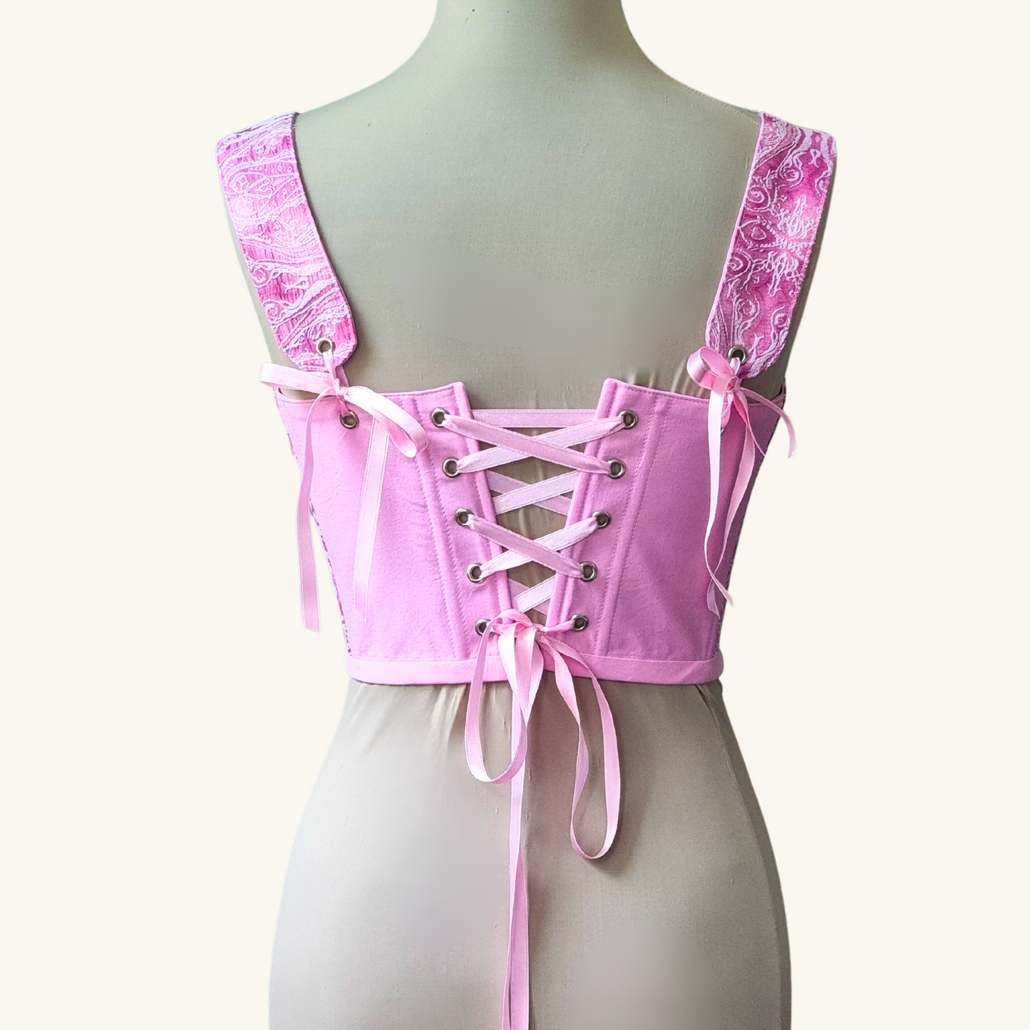 korset gledka otzad na meneken rozov ruchno izraboten s rozovi pandelki ot pamuk i jakard i metalni kapsi 